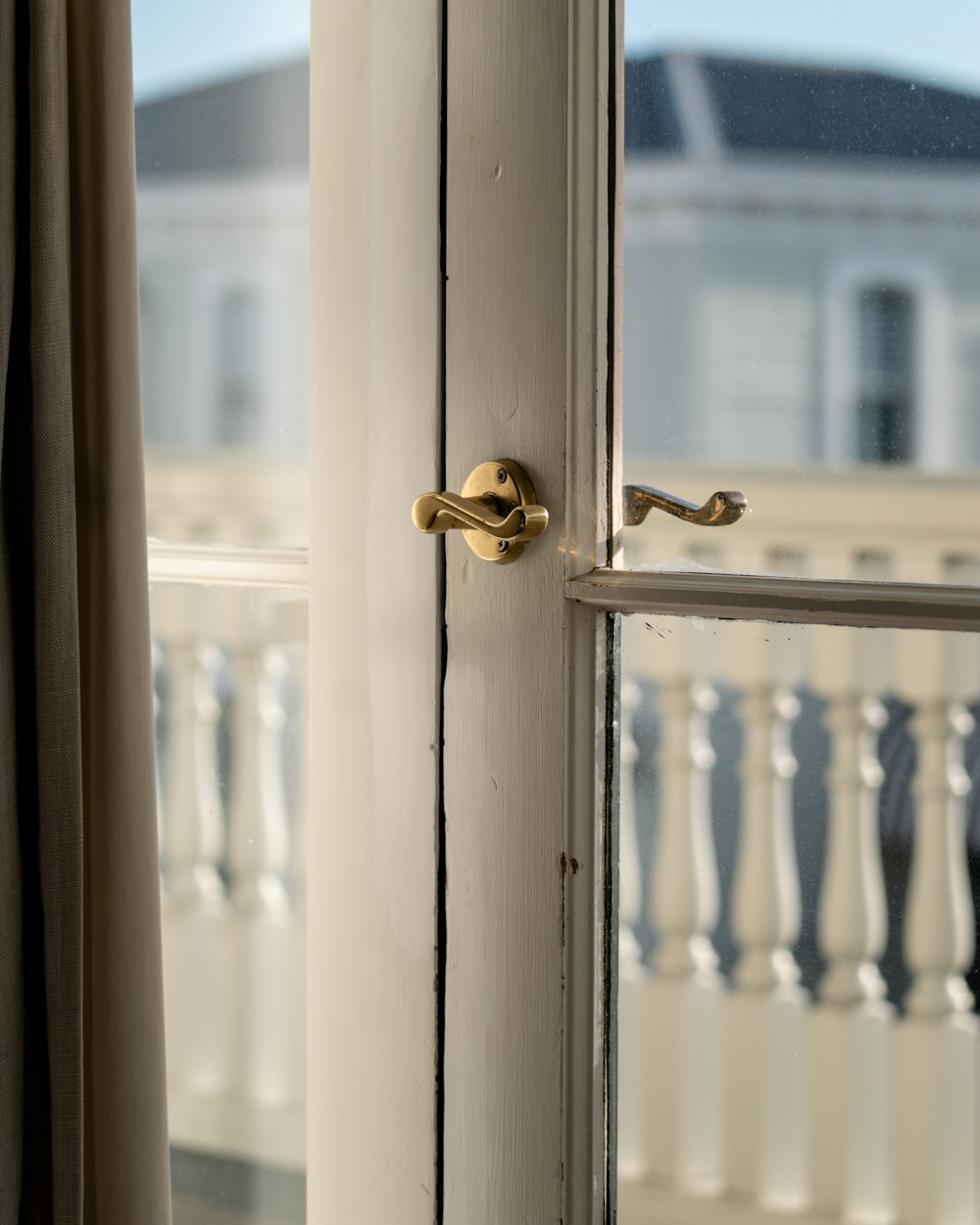 Detail okenní kliky a rámu proti světlu